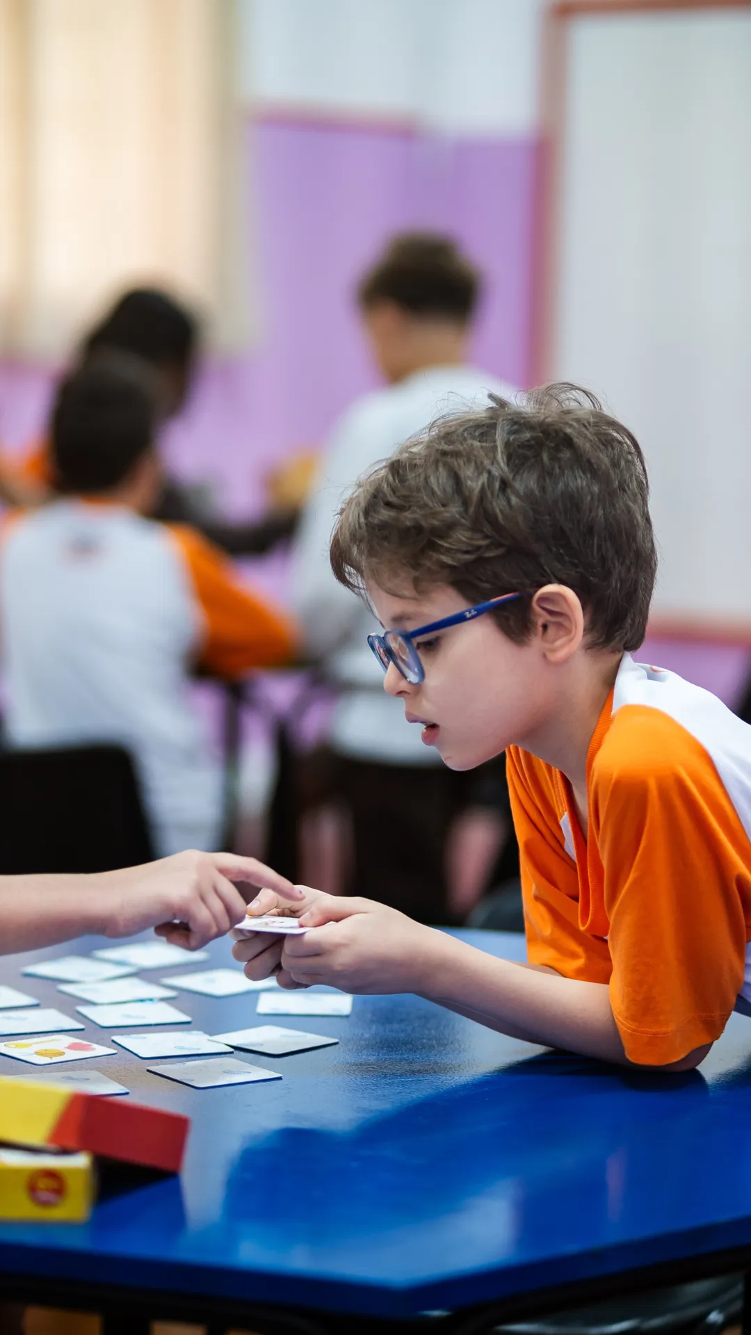 Aluno do Fundamental I em atividade com cartas na mesa