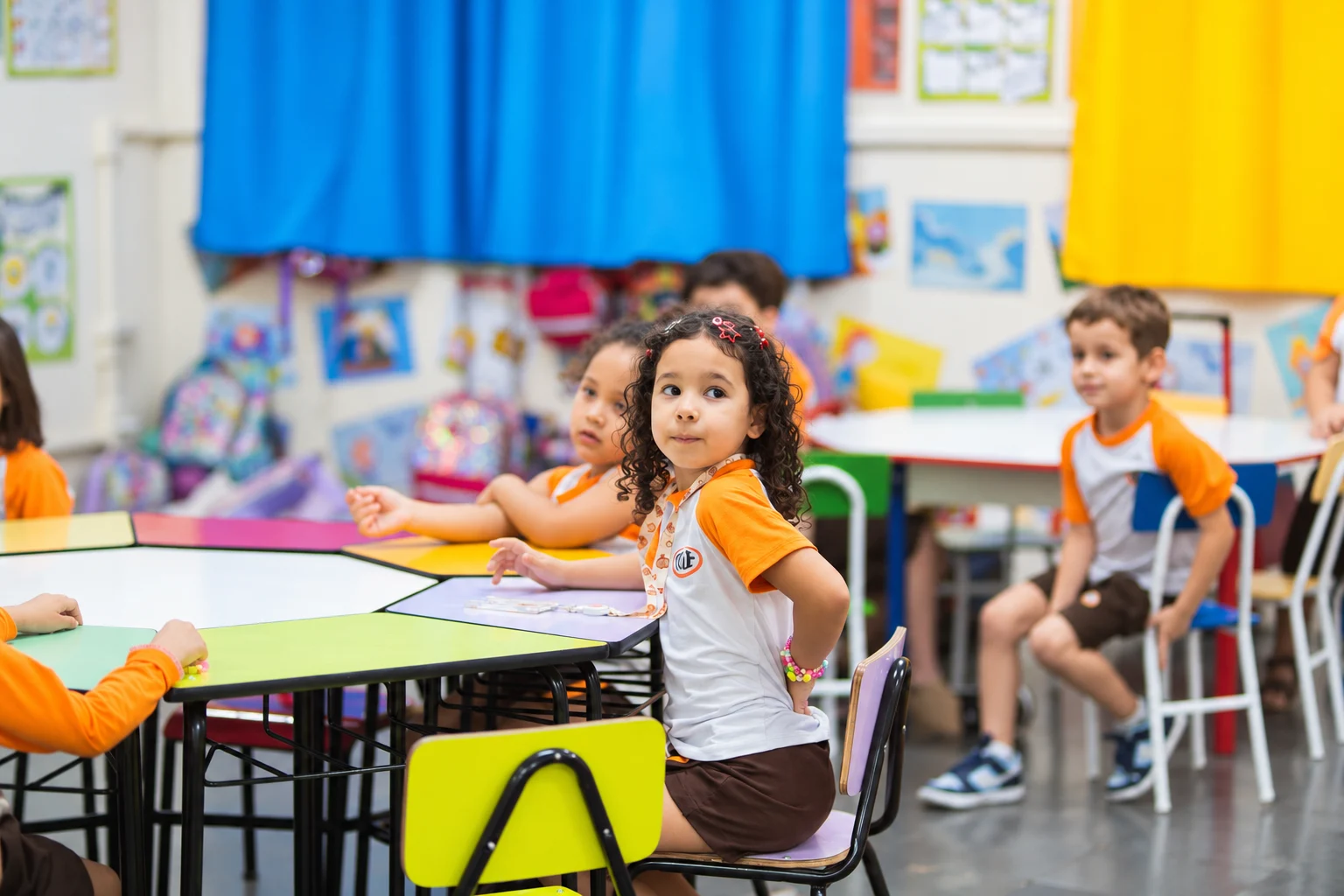 Crianças da Educação Infantil trabalham em volta das mesas coloridas