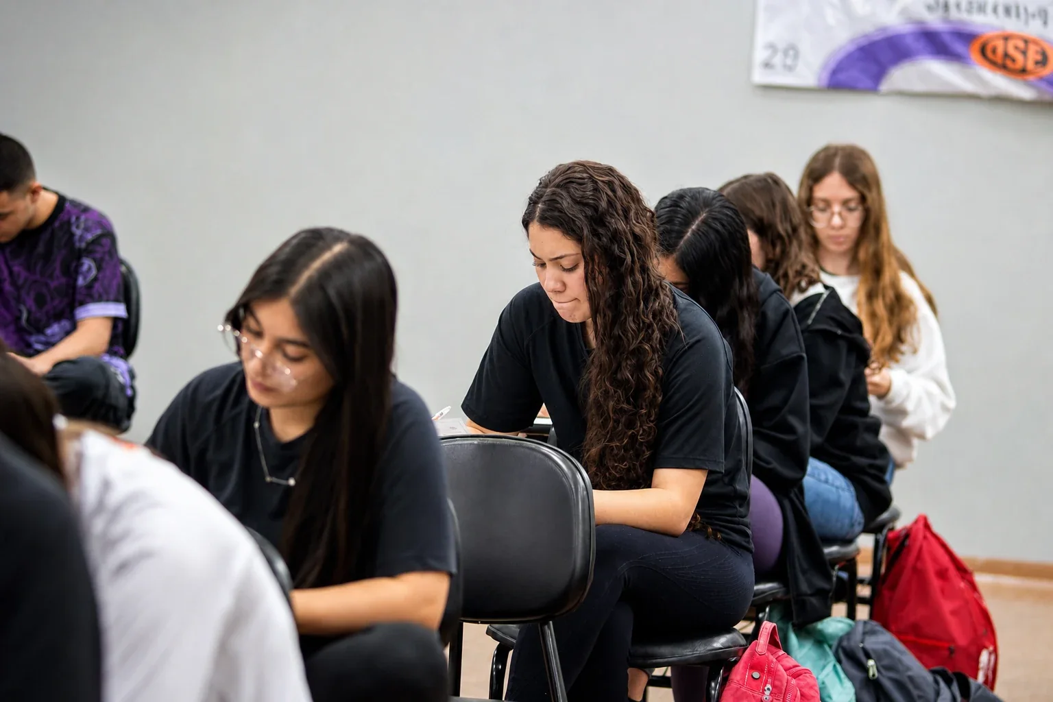 Alunas do Ensino Médio de uniforme trabalhando lado a lado